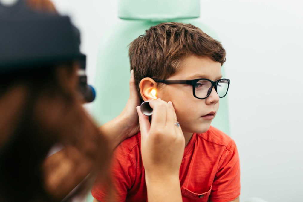 A doctor examines a boy's ear
